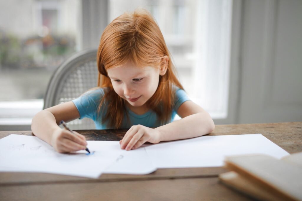 petite fille diligente dessinant sur du papier dans un salon lumineux à la maison