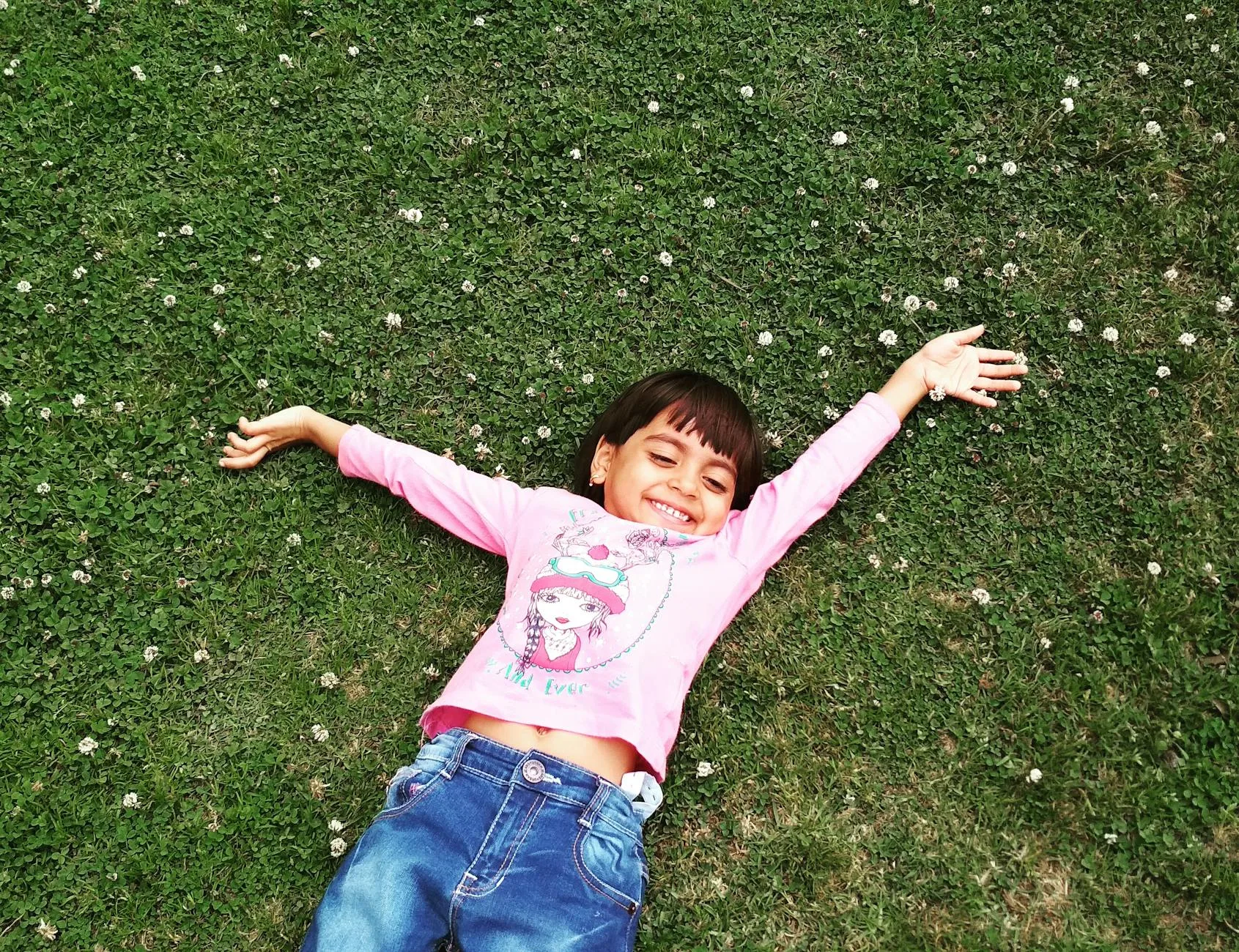 girl laying on green grass